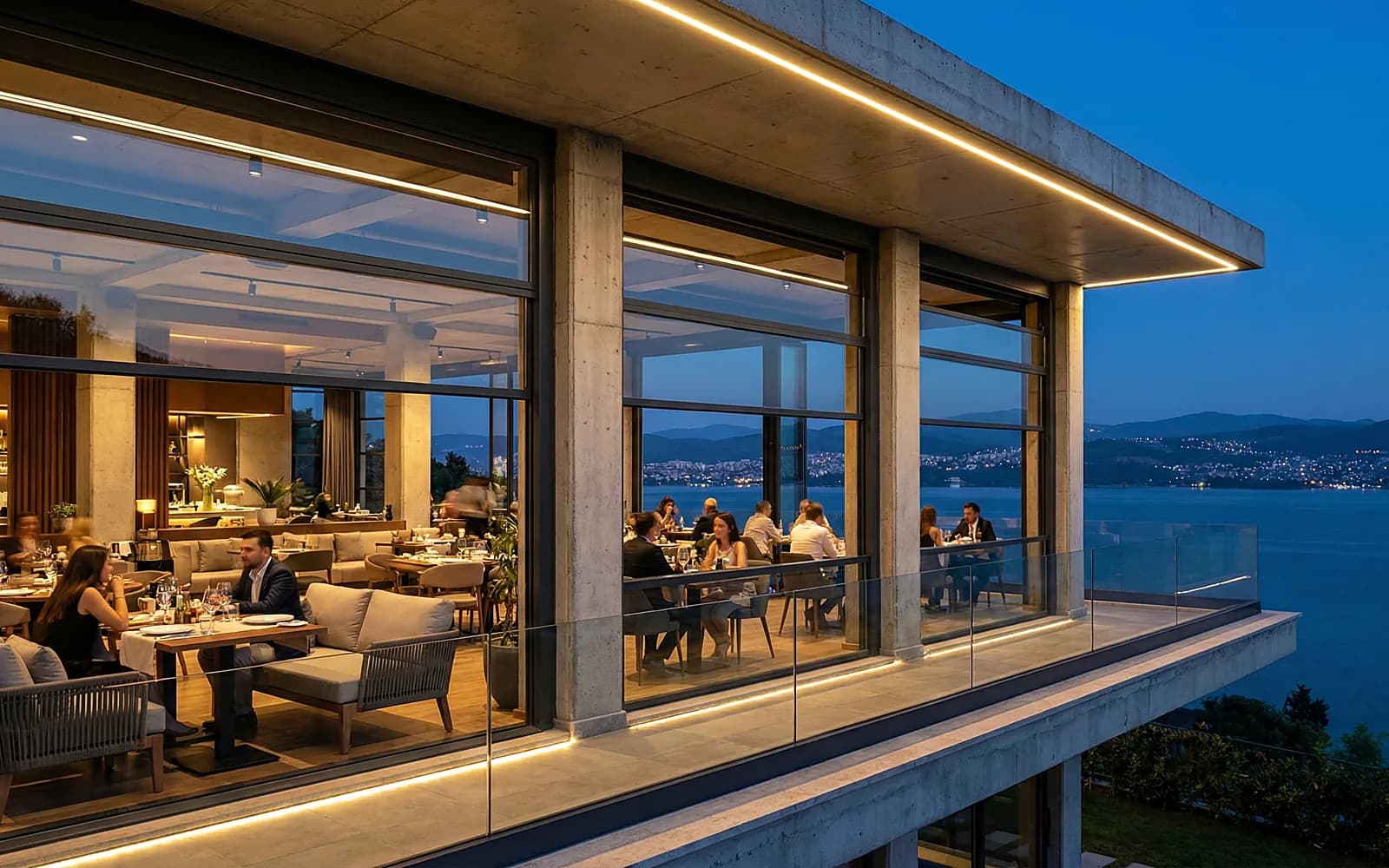 Deniz kenarında camlı restoran terası, akşam aydınlatması